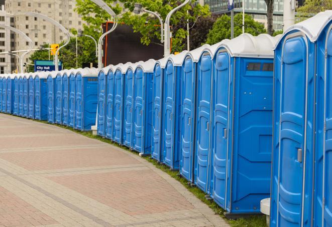 a row of portable restrooms at an outdoor special event, ready for use in Galena